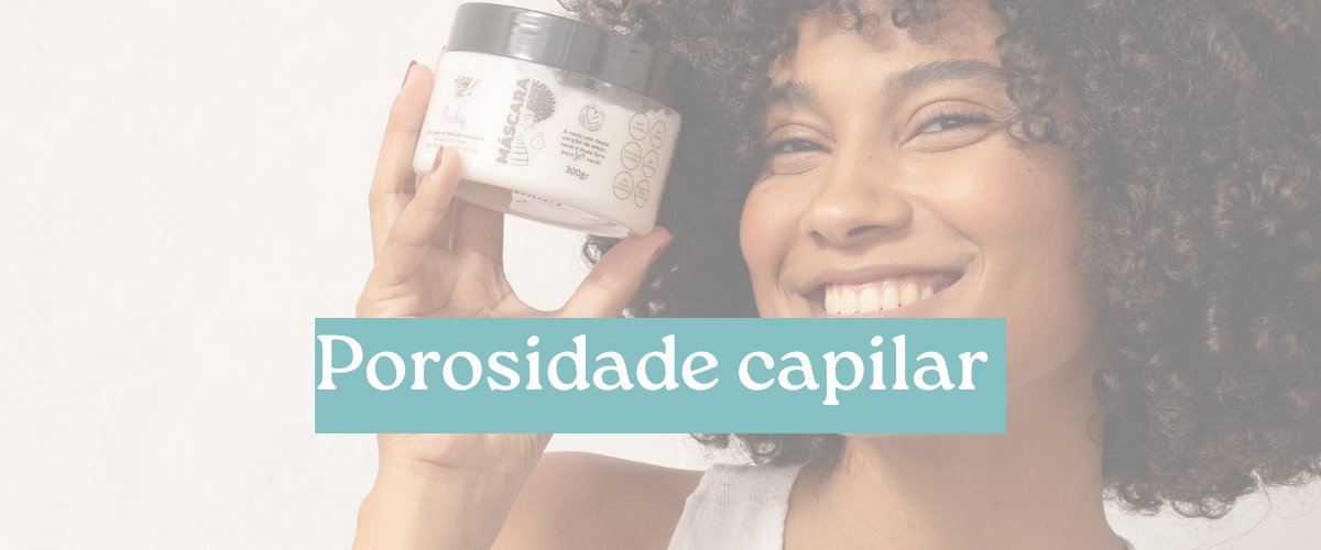 Mulher crespa sorri enquanto segura uma mascara capilar acidificante com o texto na imagem: POROSIDADE CAPILAR